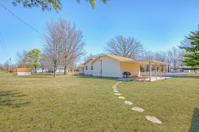 view of side of home featuring a patio and a lawn