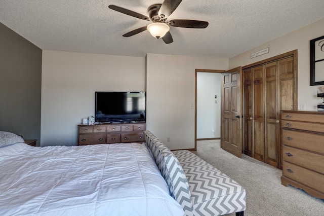 bedroom with light carpet, ceiling fan, a textured ceiling, and baseboards