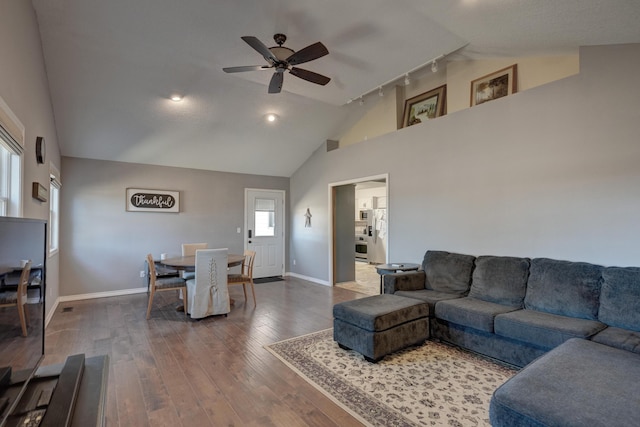 living room featuring ceiling fan, dark wood-type flooring, rail lighting, and baseboards