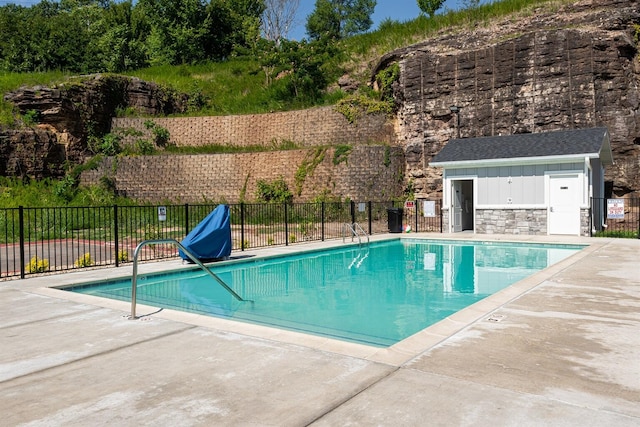 pool featuring fence, an outdoor structure, and a patio