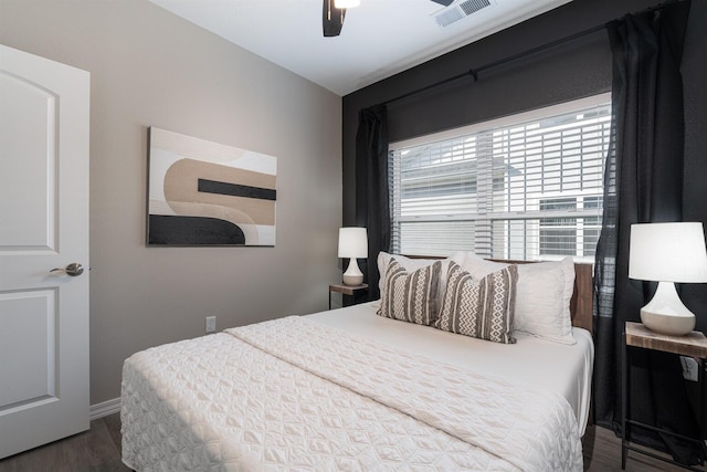 bedroom with baseboards, wood finished floors, visible vents, and a ceiling fan