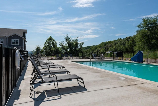 community pool featuring fence and a patio