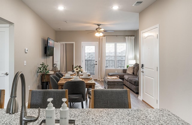 living room featuring light wood finished floors, ceiling fan, and visible vents