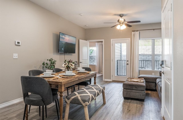 dining area with wood finished floors, a ceiling fan, and baseboards