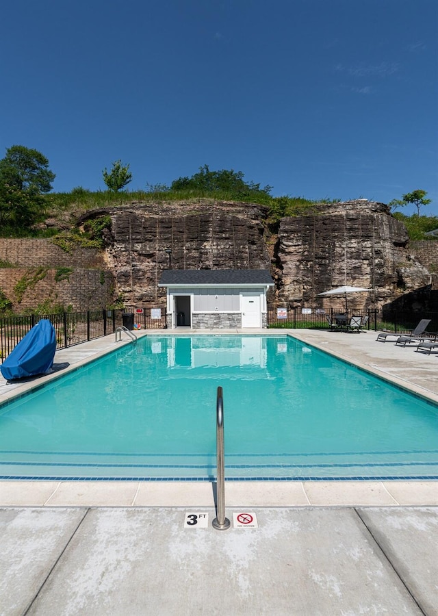 pool featuring fence and a patio