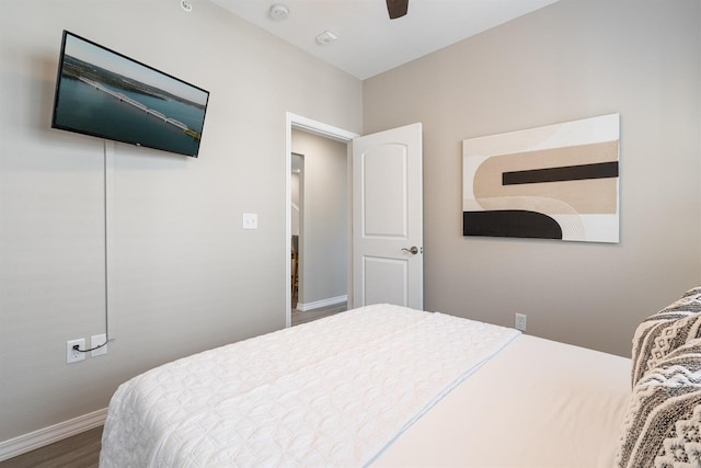 bedroom with ceiling fan, baseboards, and wood finished floors