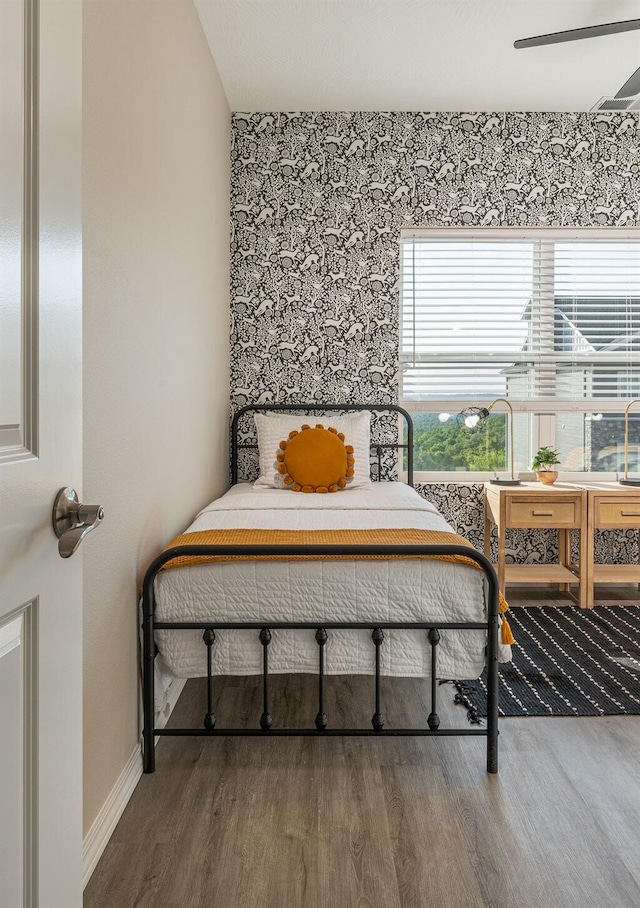 bedroom featuring baseboards and wood finished floors