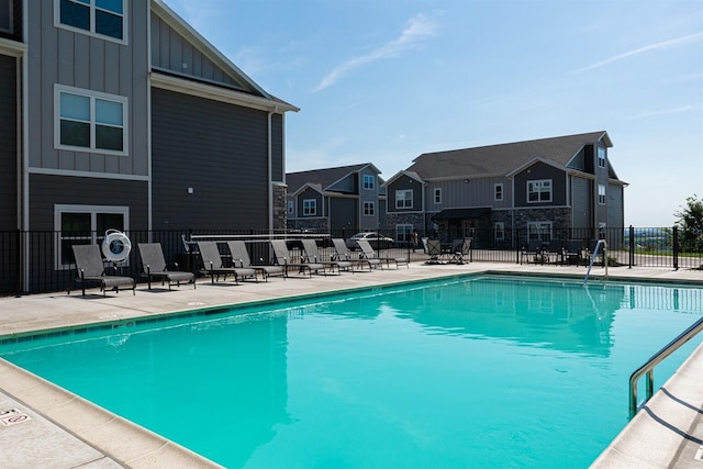 pool featuring a residential view, fence, and a patio