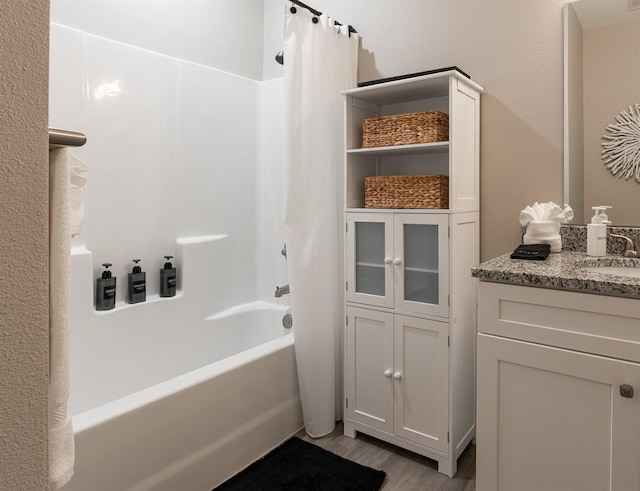 bathroom featuring wood finished floors, vanity, and shower / tub combo with curtain