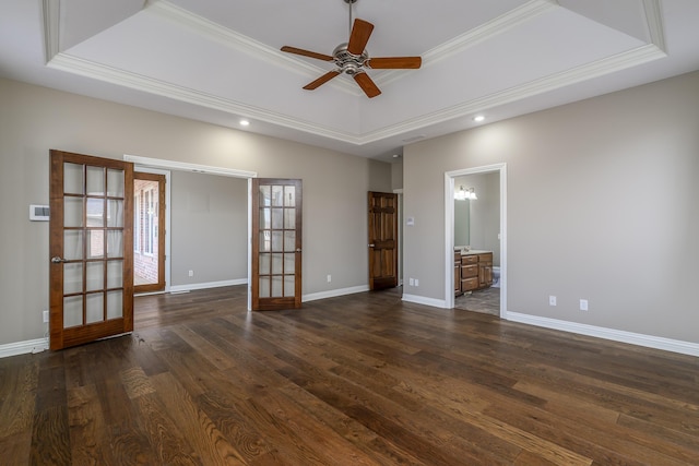 empty room featuring dark wood-type flooring, a raised ceiling, baseboards, and french doors