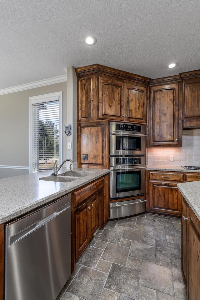 kitchen featuring a sink, appliances with stainless steel finishes, a warming drawer, tasteful backsplash, and crown molding