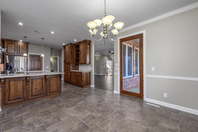 kitchen featuring stone finish flooring, baseboards, stainless steel fridge with ice dispenser, open shelves, and decorative light fixtures