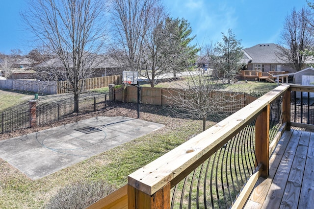 wooden deck featuring basketball court, a fenced backyard, and a lawn