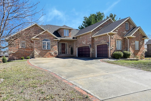 traditional-style home with driveway, a garage, roof with shingles, a front yard, and brick siding