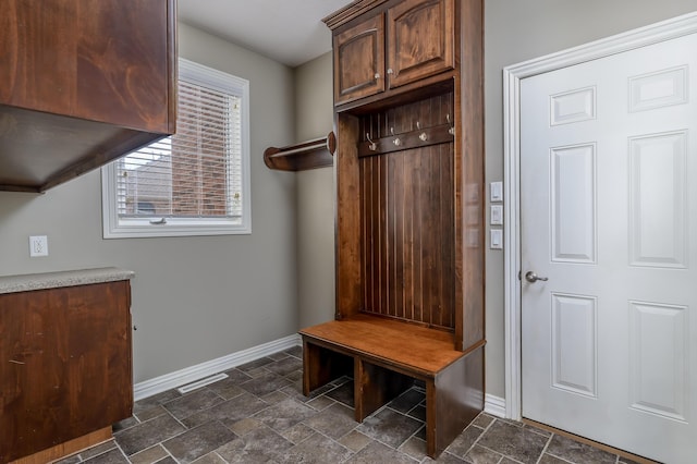 mudroom with baseboards, visible vents, and stone finish floor