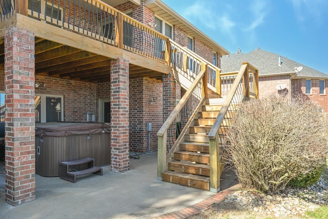 view of patio / terrace featuring stairway and a hot tub