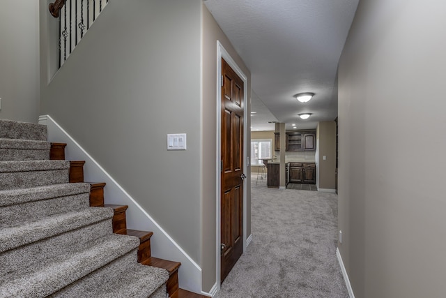 staircase featuring carpet floors and baseboards