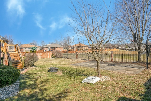 view of yard with an outdoor fire pit, stairs, a deck, and a fenced backyard