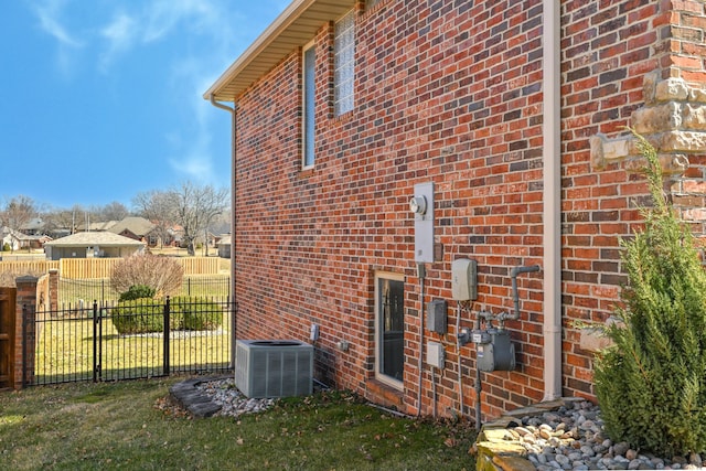 view of side of property featuring fence, cooling unit, and brick siding