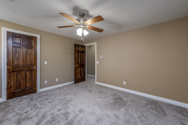 unfurnished bedroom featuring a ceiling fan, carpet flooring, a textured ceiling, and baseboards