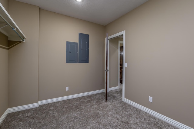 interior space with carpet, electric panel, and baseboards