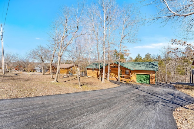 view of front of home featuring a garage, aphalt driveway, and covered porch