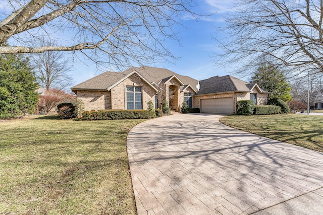 view of front of property featuring an attached garage, brick siding, a shingled roof, driveway, and a front lawn