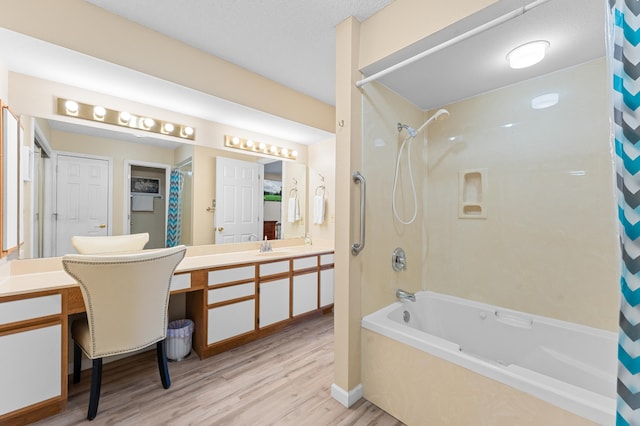 bathroom featuring wood finished floors, shower / bath combo with shower curtain, and vanity