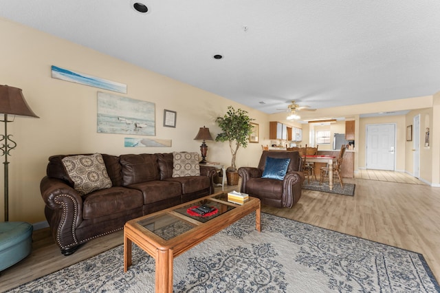 living room with a ceiling fan and wood finished floors