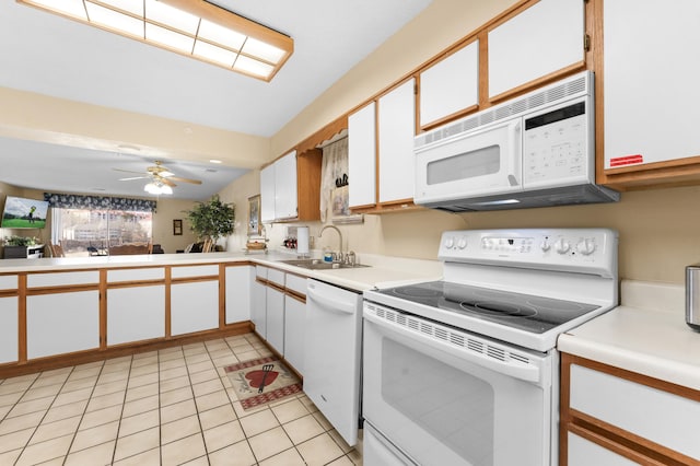 kitchen with light tile patterned floors, light countertops, white appliances, and a sink