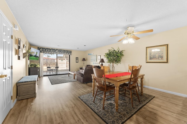 dining room featuring wood finished floors, a ceiling fan, and baseboards