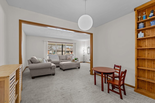 living room featuring light carpet and baseboards