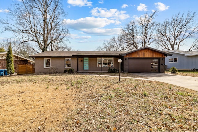 view of front of property with an attached garage, fence, concrete driveway, and brick siding