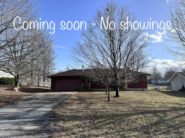 view of front of property featuring aphalt driveway, an attached garage, and fence