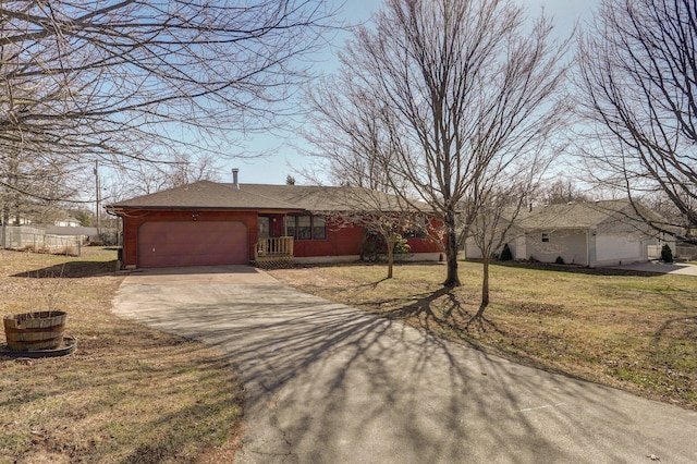 ranch-style house featuring concrete driveway, a garage, and a front yard