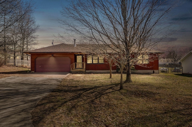 view of front facade with a garage, a lawn, concrete driveway, and fence