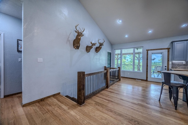 interior space featuring lofted ceiling, light wood finished floors, baseboards, and recessed lighting