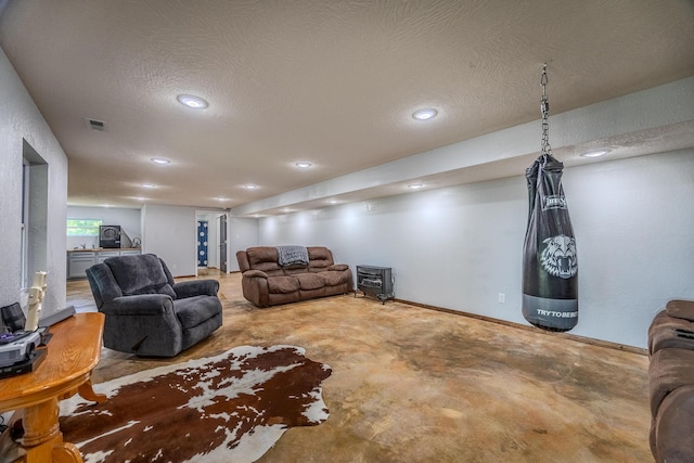 living area featuring recessed lighting, visible vents, a textured ceiling, concrete floors, and baseboards