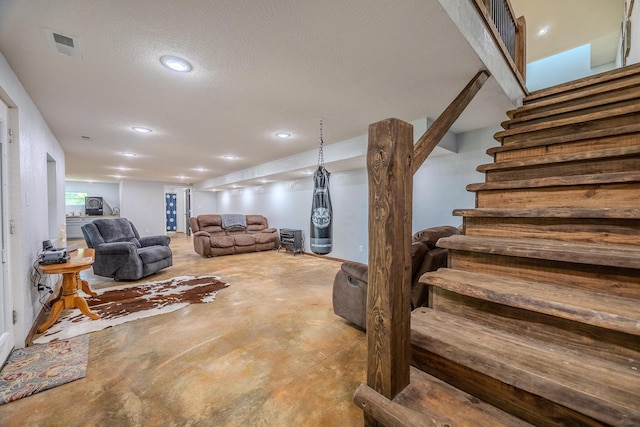 living room with concrete flooring, a textured ceiling, recessed lighting, visible vents, and stairs