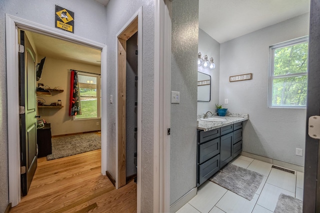 bathroom with baseboards, visible vents, wood finished floors, and vanity