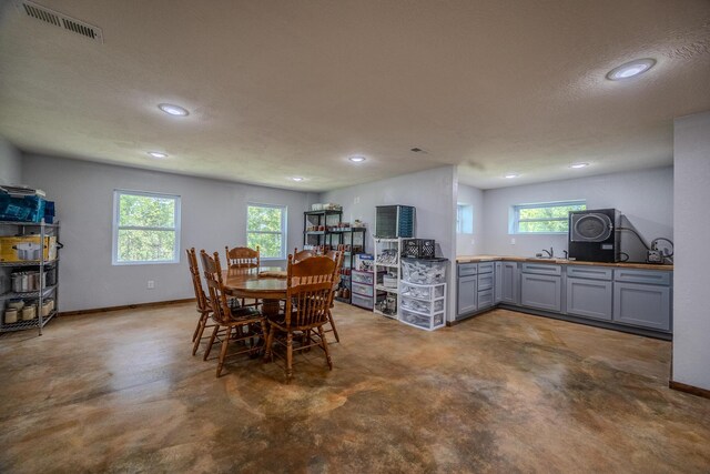 dining area featuring baseboards, visible vents, concrete flooring, and recessed lighting