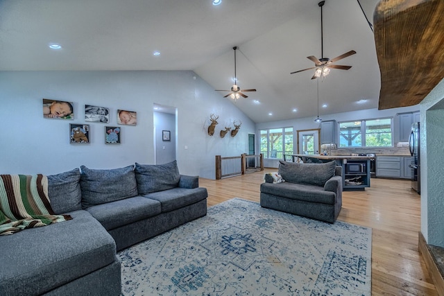 living area with light wood finished floors, ceiling fan, high vaulted ceiling, and recessed lighting