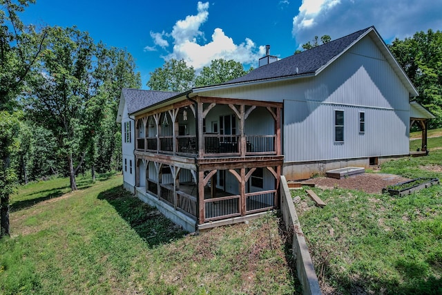 back of property featuring a shingled roof, a lawn, a chimney, and a sunroom