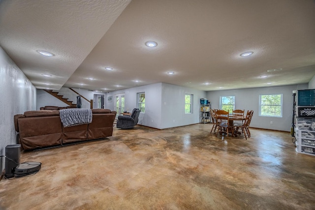 interior space with baseboards, stairs, a textured ceiling, concrete flooring, and recessed lighting