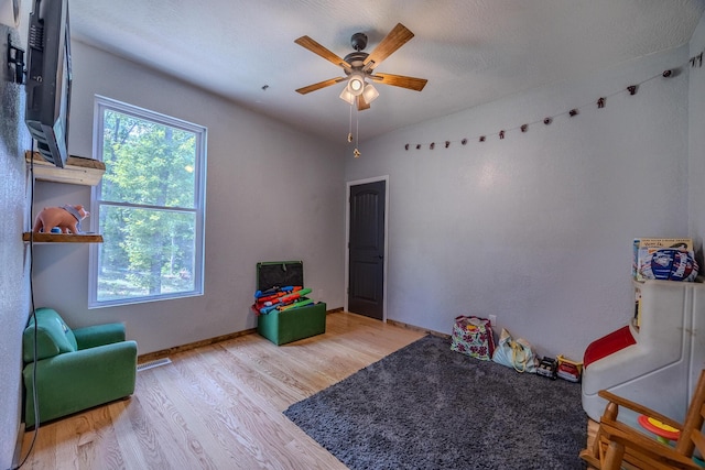 game room with light wood-type flooring and ceiling fan