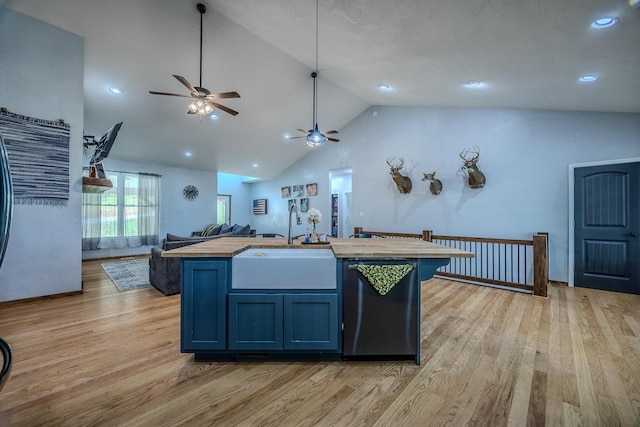 kitchen featuring open floor plan, dishwashing machine, light wood-type flooring, and a sink