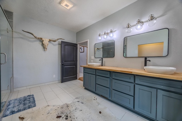 full bathroom featuring double vanity, a shower stall, visible vents, and a sink