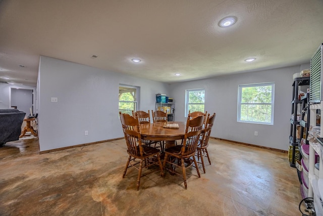 dining area with finished concrete floors, recessed lighting, plenty of natural light, and baseboards