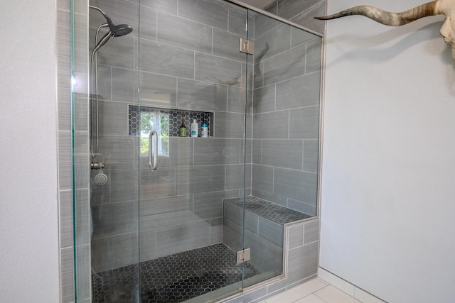 bathroom with a shower stall and tile patterned floors