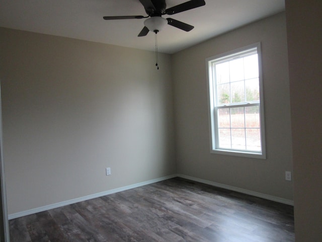 spare room with a ceiling fan, dark wood-style flooring, and baseboards